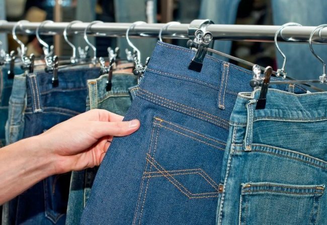 Man in the wear store choosing blue jeans