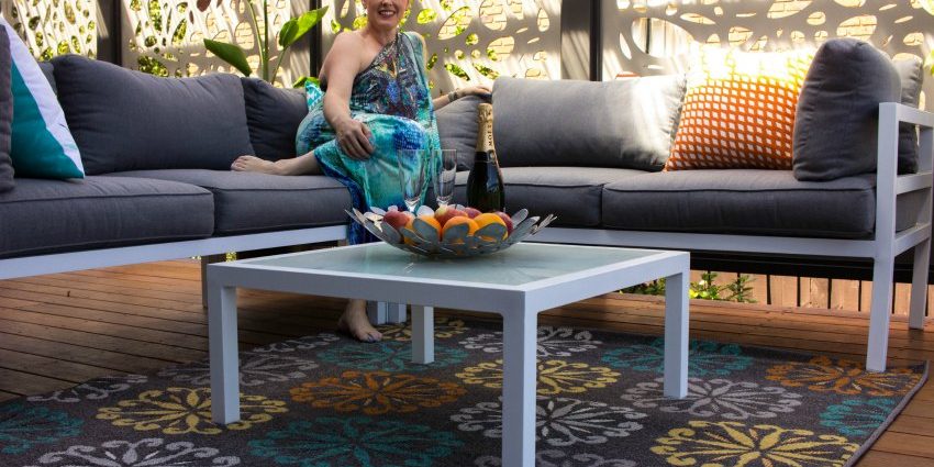 Create an outdoor living space with rugs and soft furnishings
